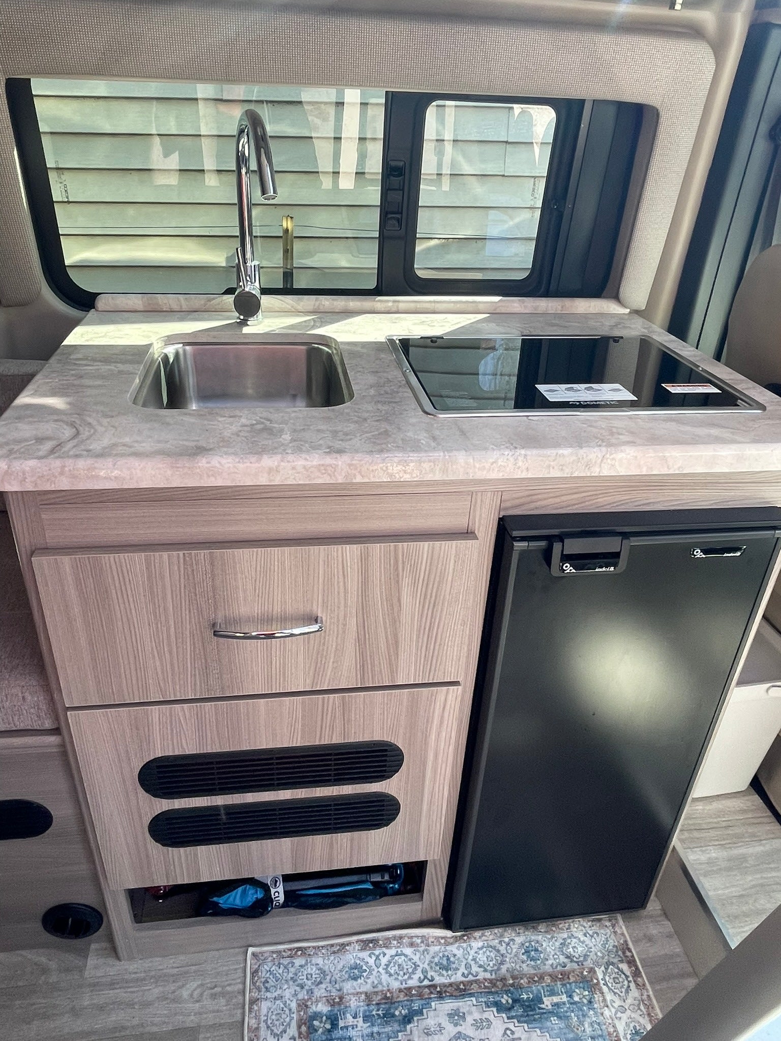 and built-in fridge.|Grey camper van RV rental with pop-top tent