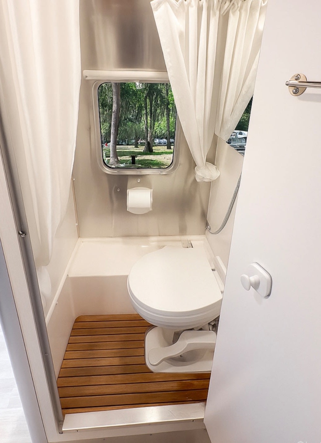 nestled among tall trees in the outdoors.|Modern rv rental interior with compact kitchen