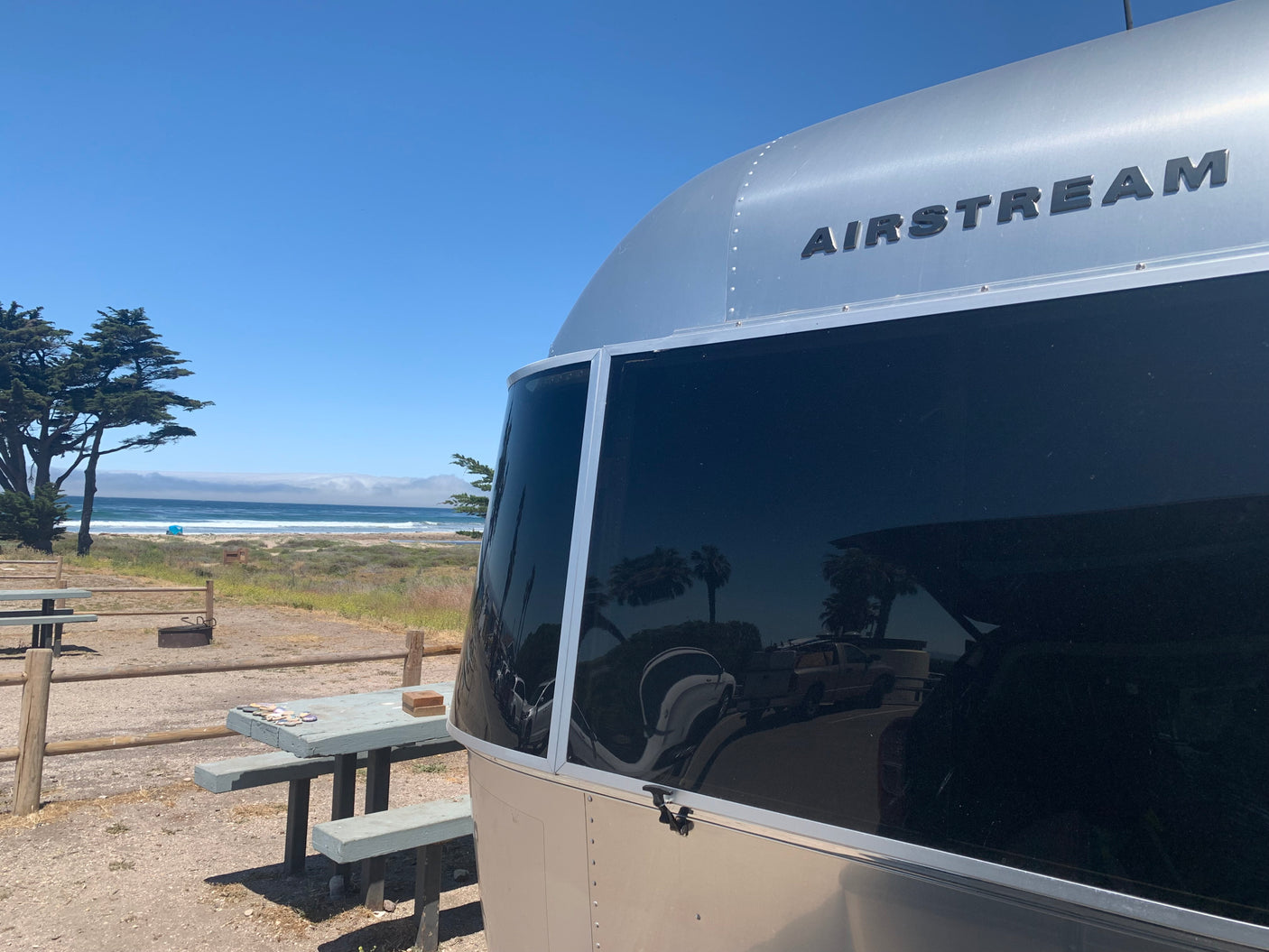 This Airstream RV rental offers beachfront camping, complete with picnic table and ocean views. Perfect for a travel escape!
