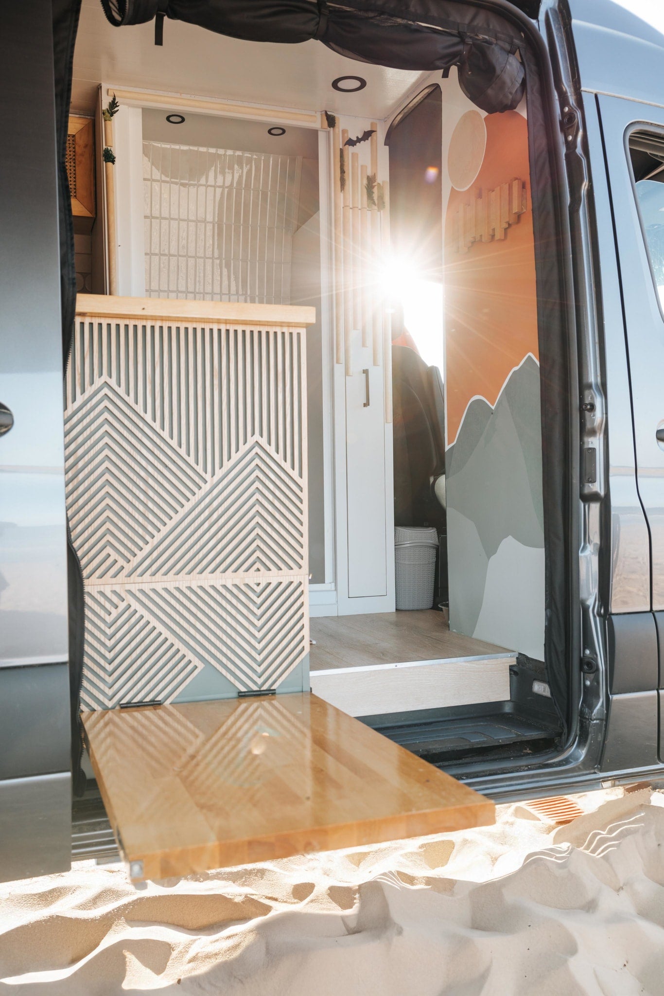 glows golden on a desert road at sunset.|RV rental kitchen with a stunning mountain view through the window. Features a stove