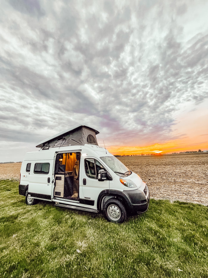 beside a field at sunset. Ideal for an RV rental journey!|RV rental interior: cozy seating