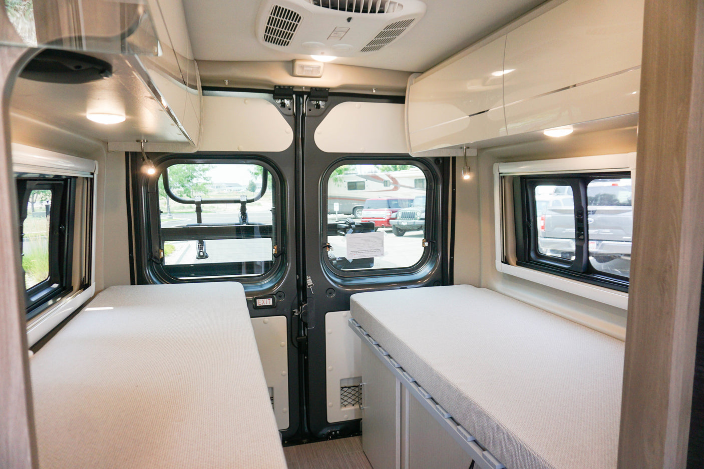 Experience comfort in this RV rental's versatile interior, featuring twin beds, bright windows, and ample storage.