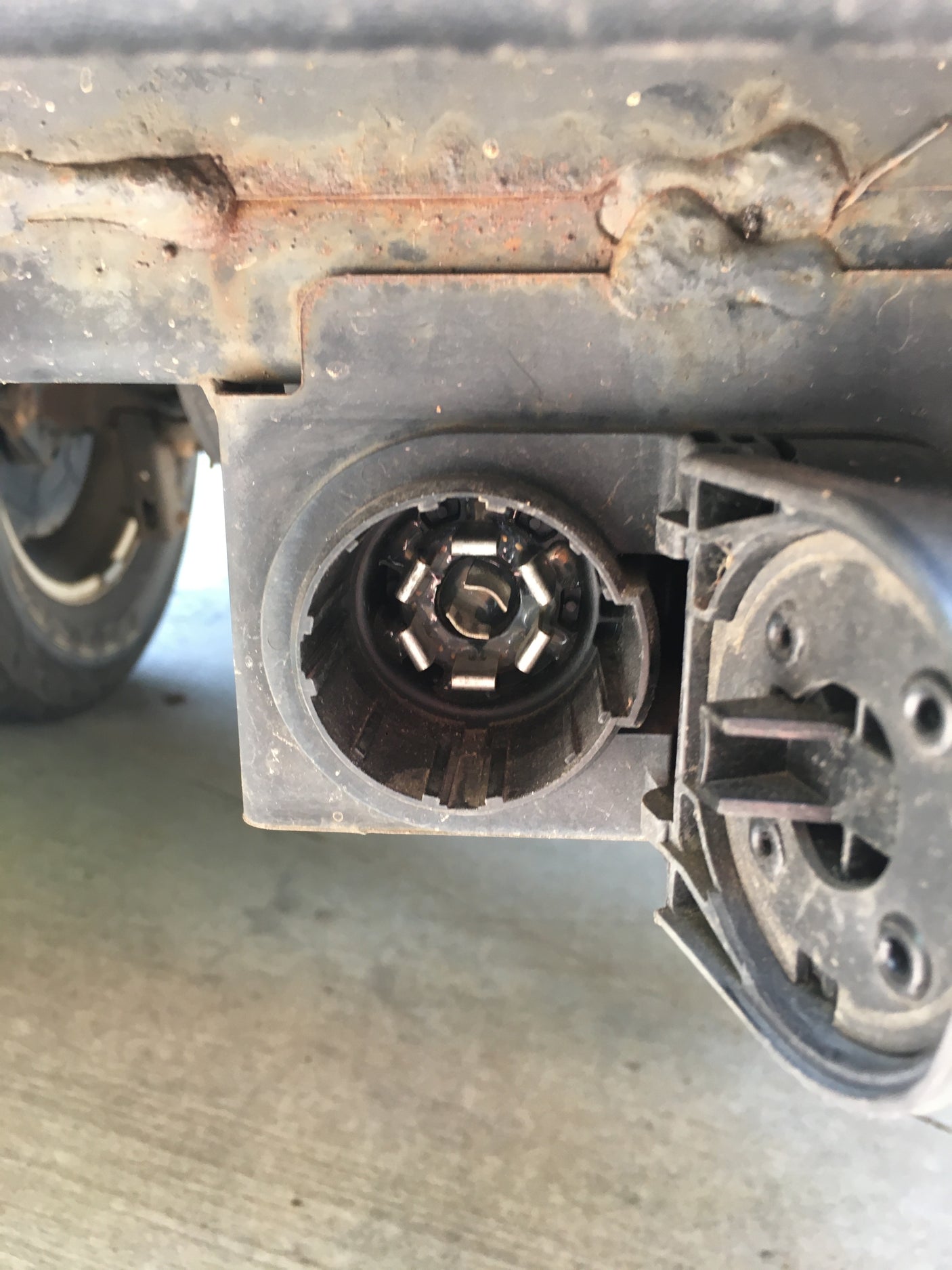 A 7-pin trailer wiring connector, common for an RV rental, enabling power & lights for towing. Visible rust on the chassis.