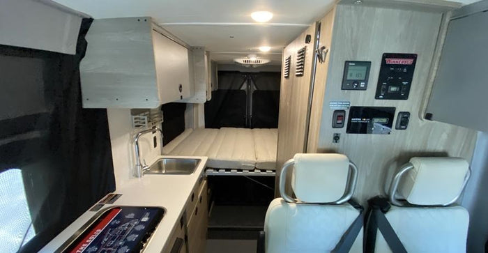 and bike rack with a mountain bike.|Modern RV rental interior features comfy quilted seats