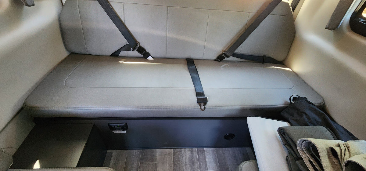 RV rental's rear bench seat, beige upholstery, three seatbelts, carbon monoxide detector, and floor storage. — photo 9