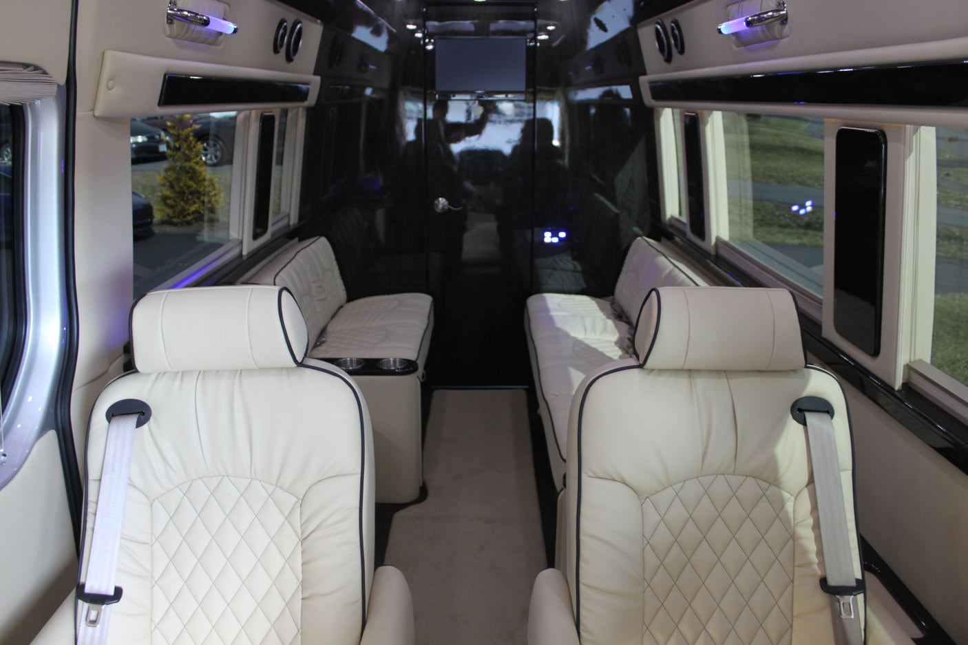 Explore our luxurious RV rental interior. Features include plush cream quilted leather seats, large side windows, and spacious comfort for travel.