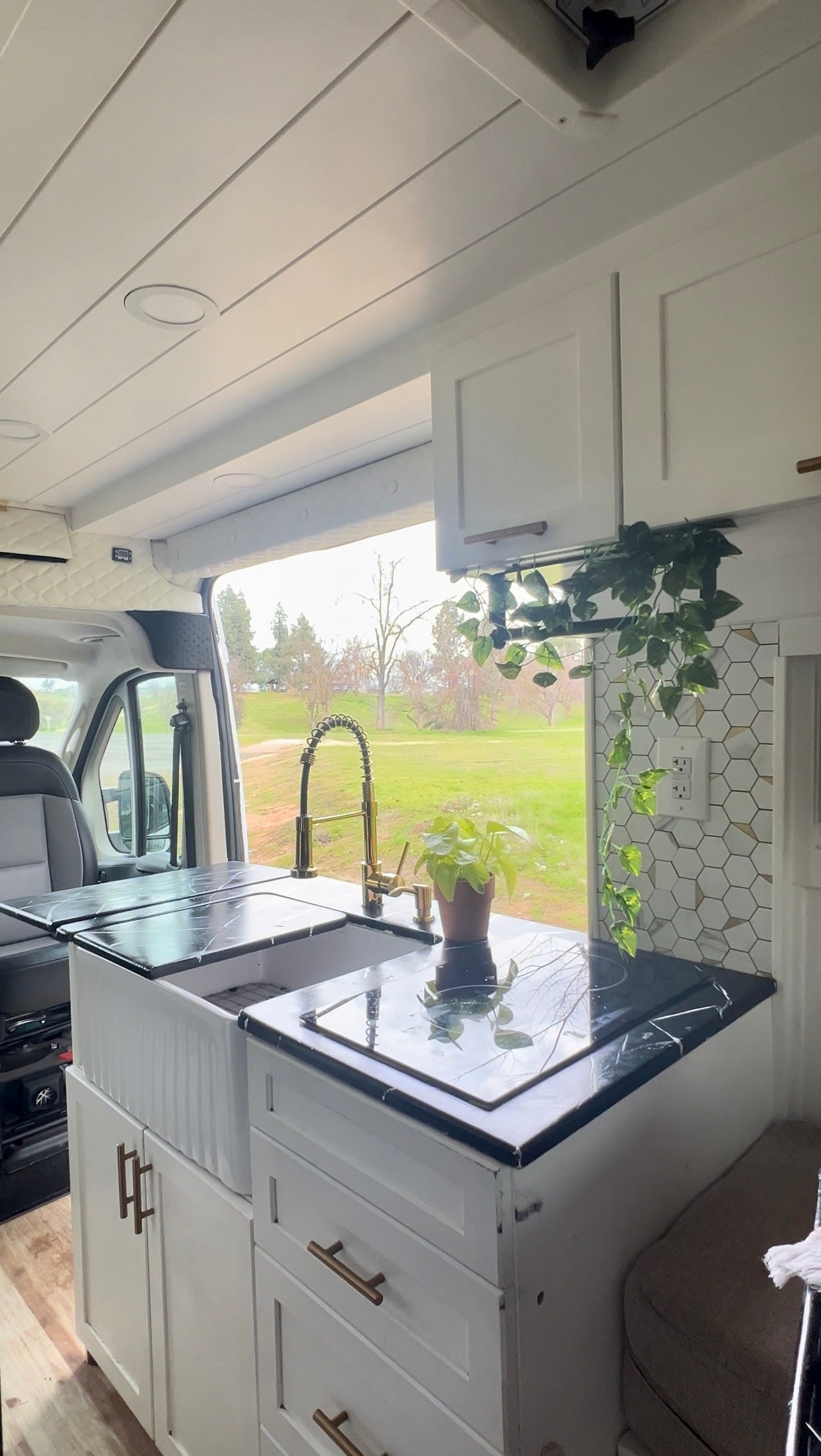 This RV rental kitchen features a modern sink, cooktop, and ample storage for comfortable mobile living. — photo 9