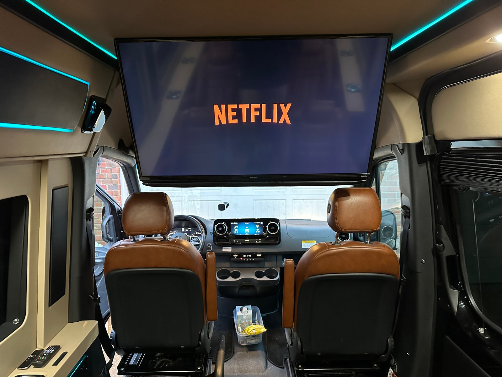 with a celebratory blue bow.|Plush brown leather captain's chairs fill this luxury RV rental