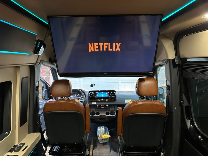 with a celebratory blue bow.|Plush brown leather captain's chairs fill this luxury RV rental