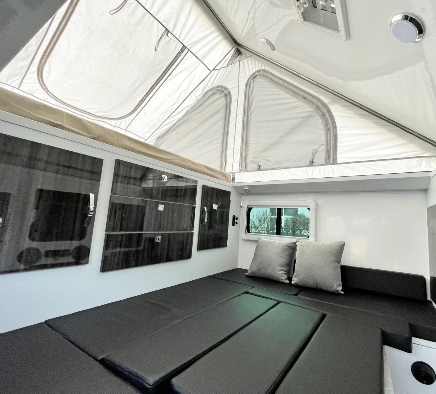 and an outdoor kitchen.|Cozy pop-up RV rental interior: dining area with table
