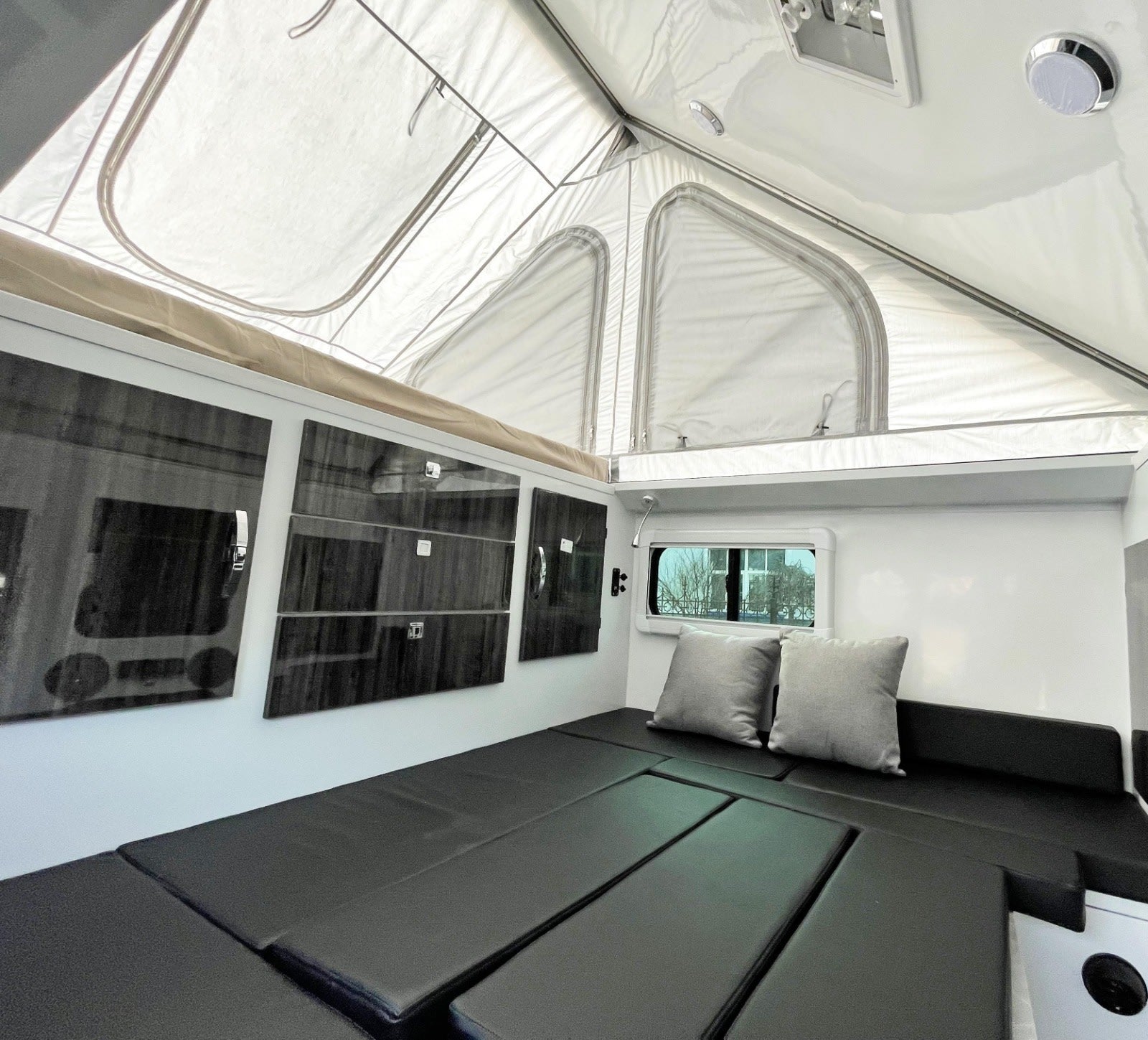 and an outdoor kitchen.|Cozy pop-up RV rental interior: dining area with table
