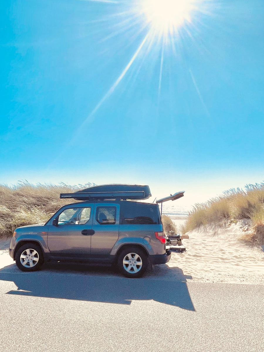 Sunny beach day with a versatile Honda Element, equipped for adventure. Perfect alternative to an RV rental for road trips & camping.