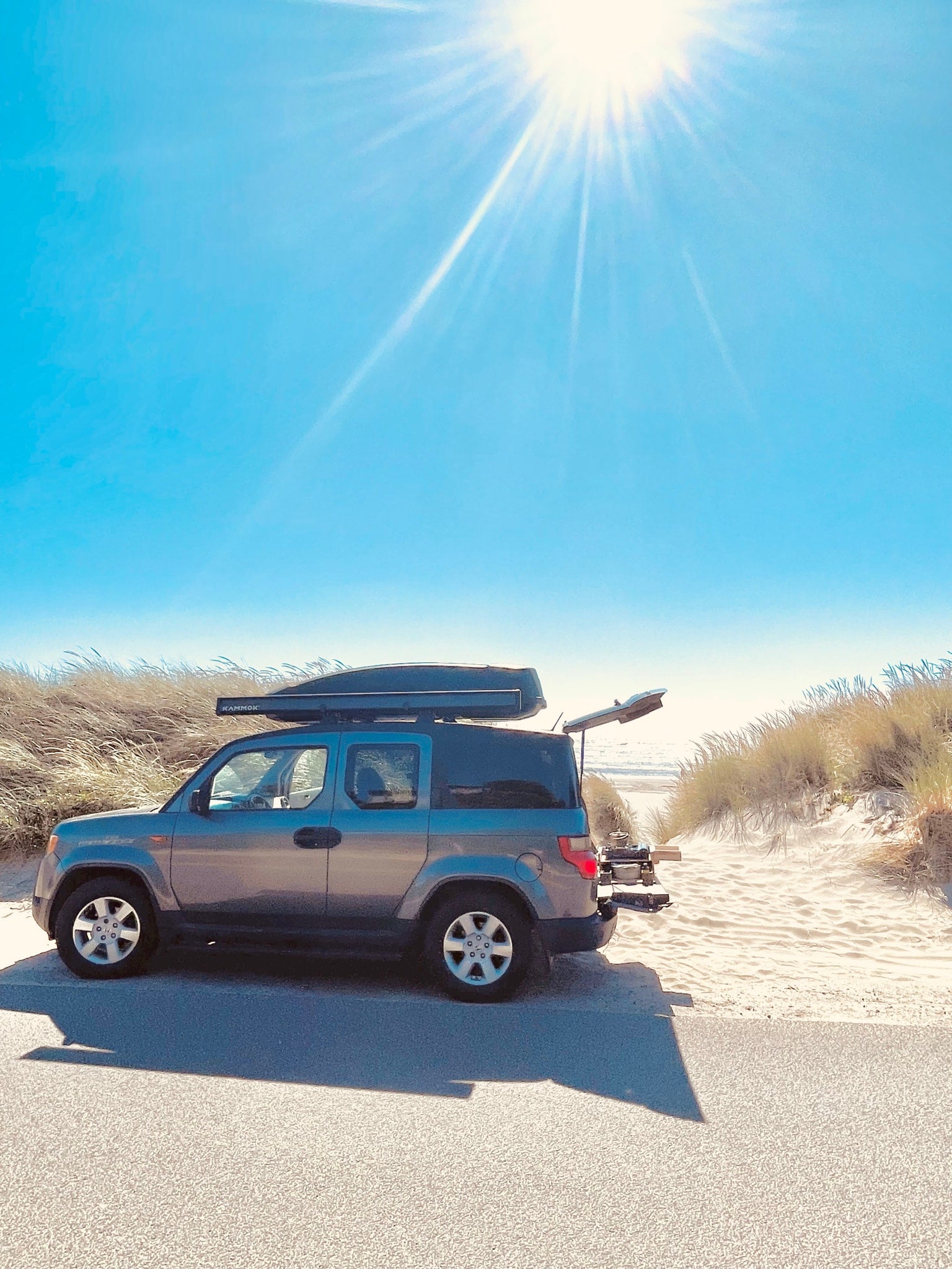 Sunny beach day with a versatile Honda Element, equipped for adventure. Perfect alternative to an RV rental for road trips & camping.