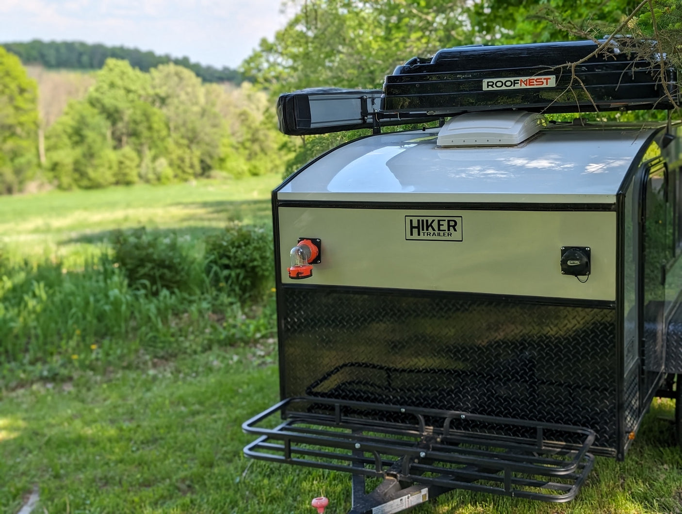 promotes tidiness for adventures.|Baby views lush nature from a rooftop tent on an RV rental adventure