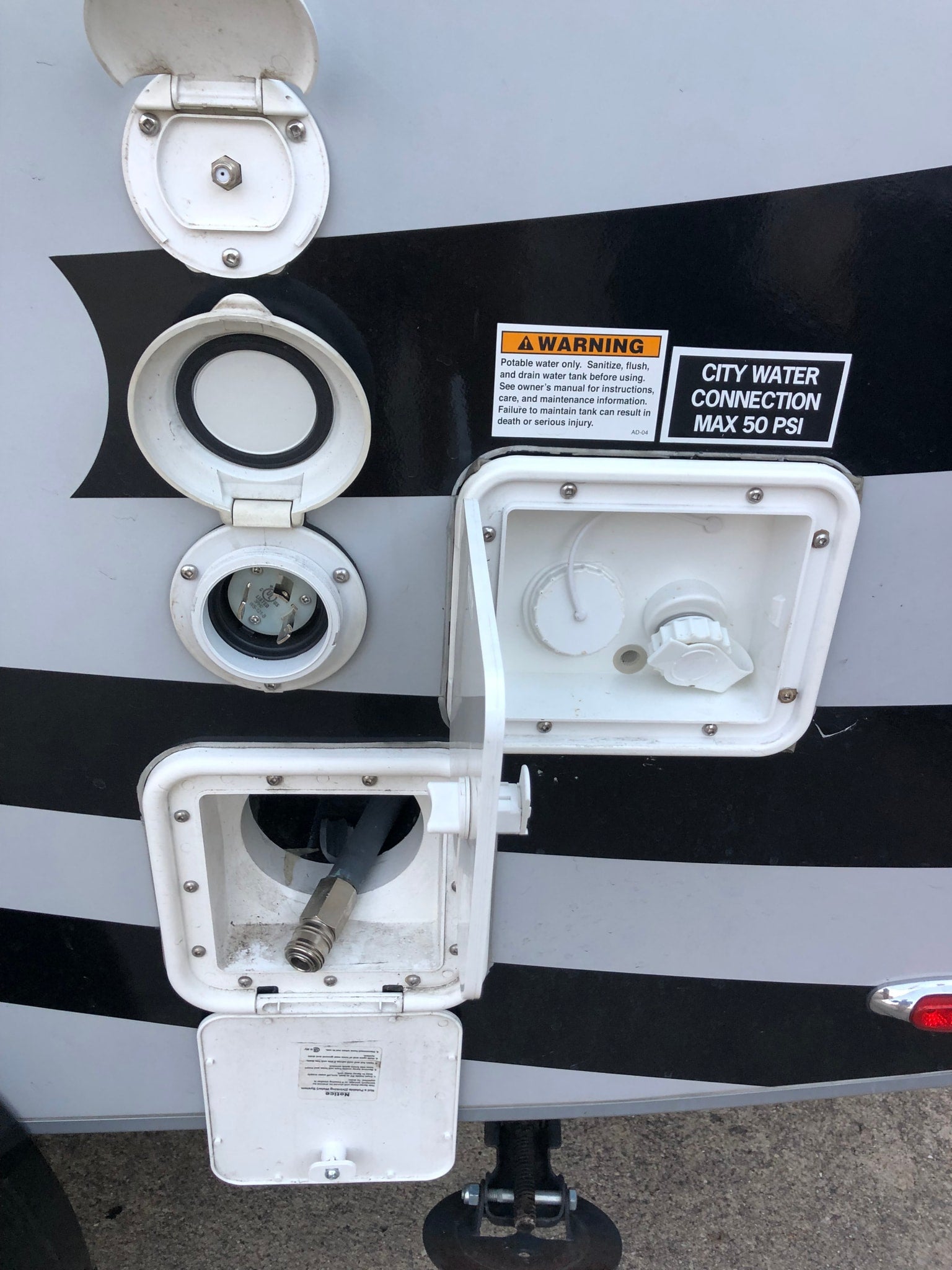 RV rental external connections: water hookup (max 50 PSI), electric shore power, cable, and quick-connect hose.