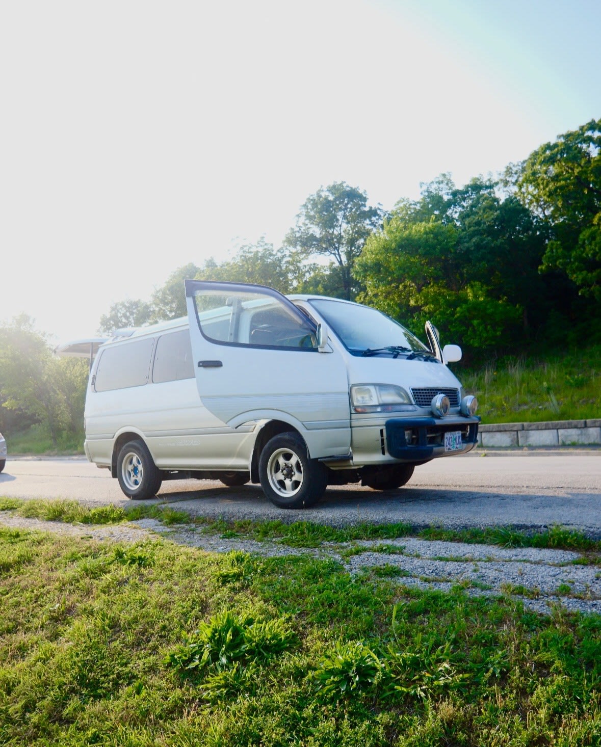 tree-lined road with other vehicles.|White van