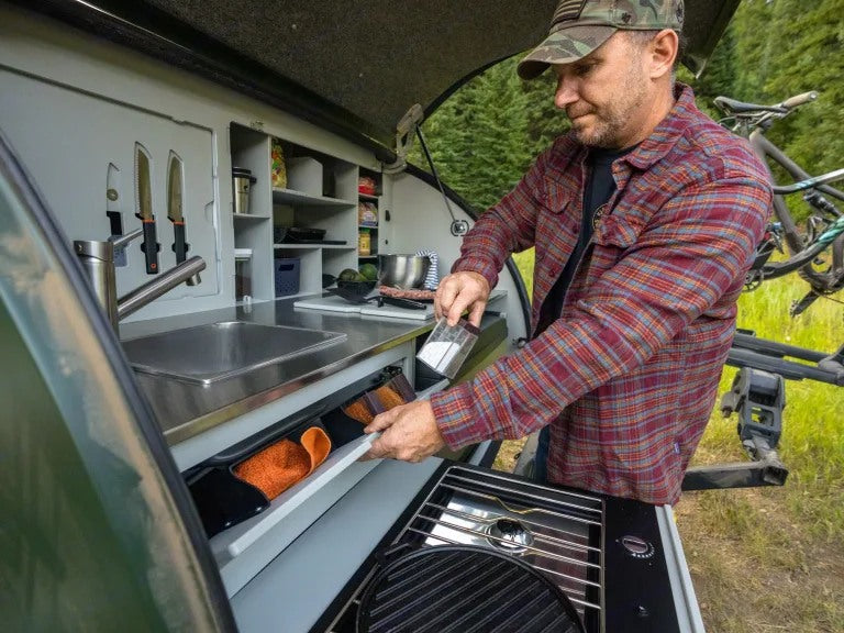 Enjoy outdoor cooking with an RV rental! This camper's kitchen has a sink, grill, and storage for easy camp meals.