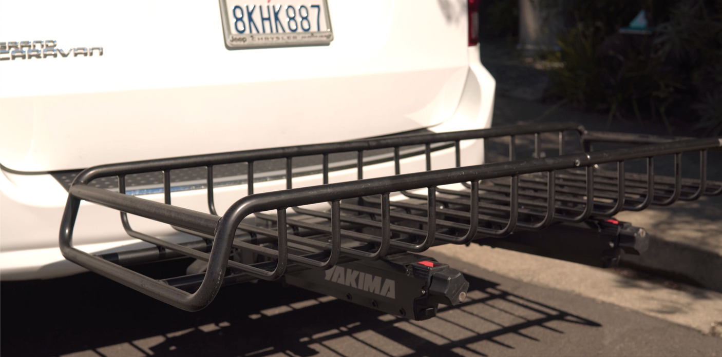 RV rental: Rear of a white Chrysler Grand Caravan with a black Yakima cargo hitch basket for extra storage.