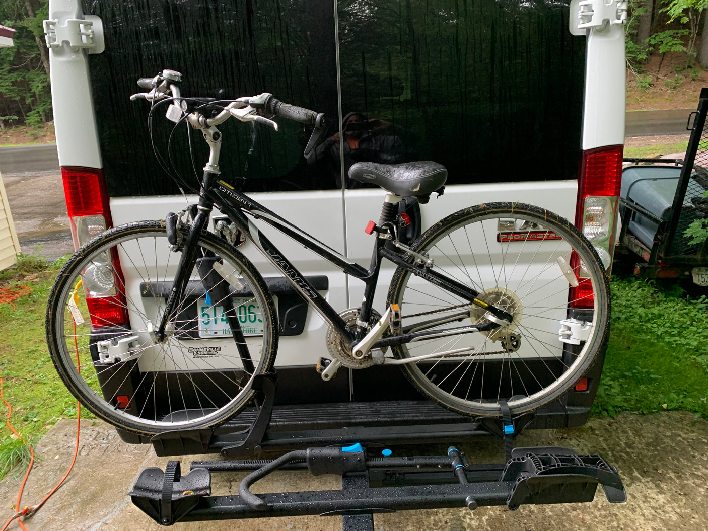 A Jamis Citizen bike on a rear rack of a white rv rental van, hinting at road trips & nature exploration.