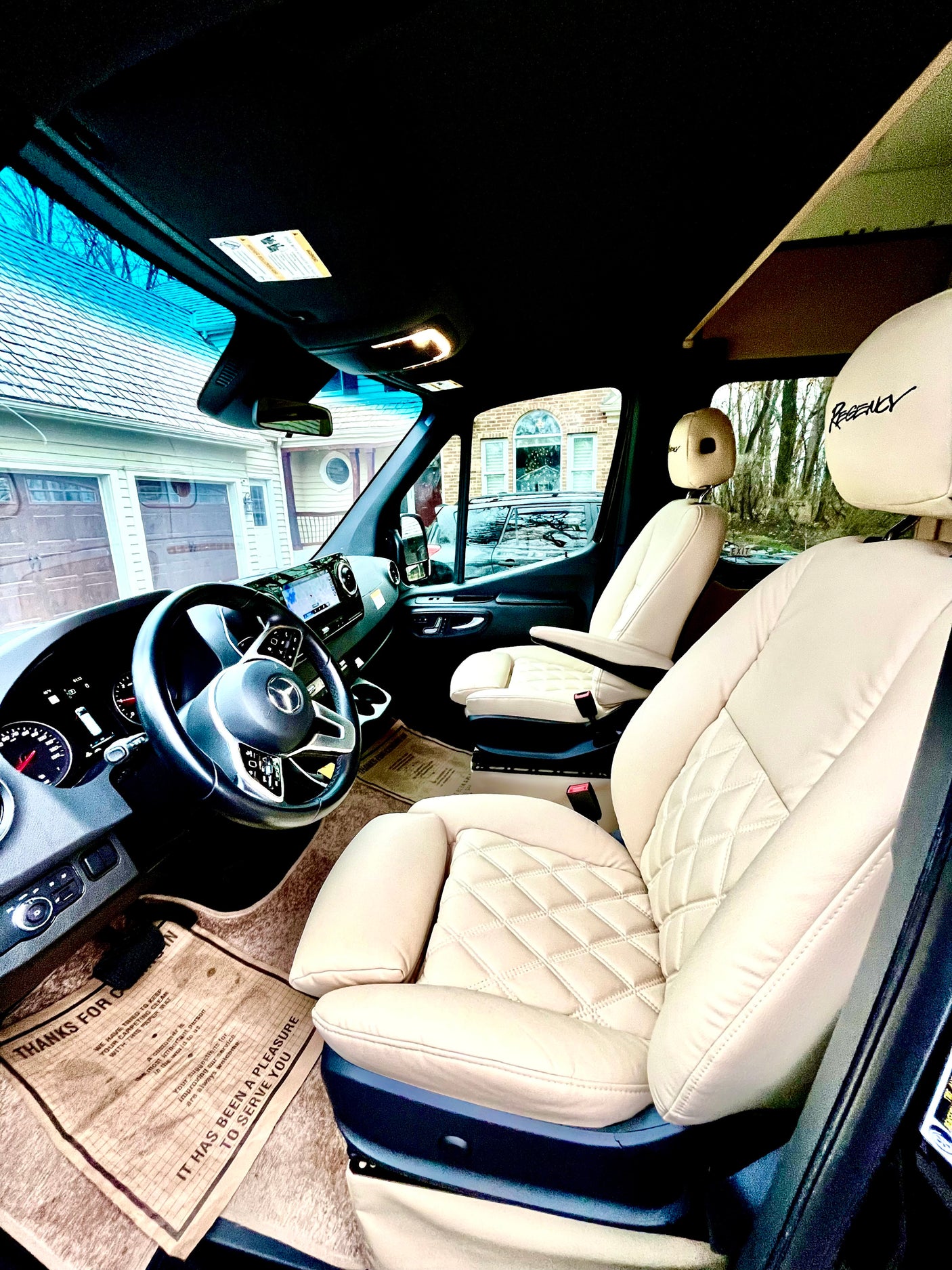 Experience the luxurious interior of this RV rental, featuring cream quilted leather seats and a modern Mercedes-Benz van cockpit.
