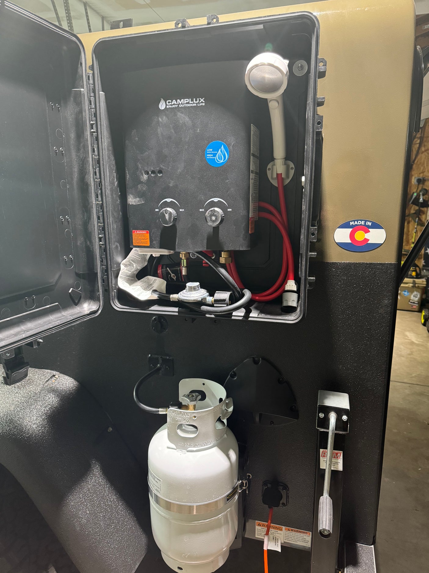 Portable hot water heater setup with propane tank for an rv rental, perfect for outdoor showers and camping.