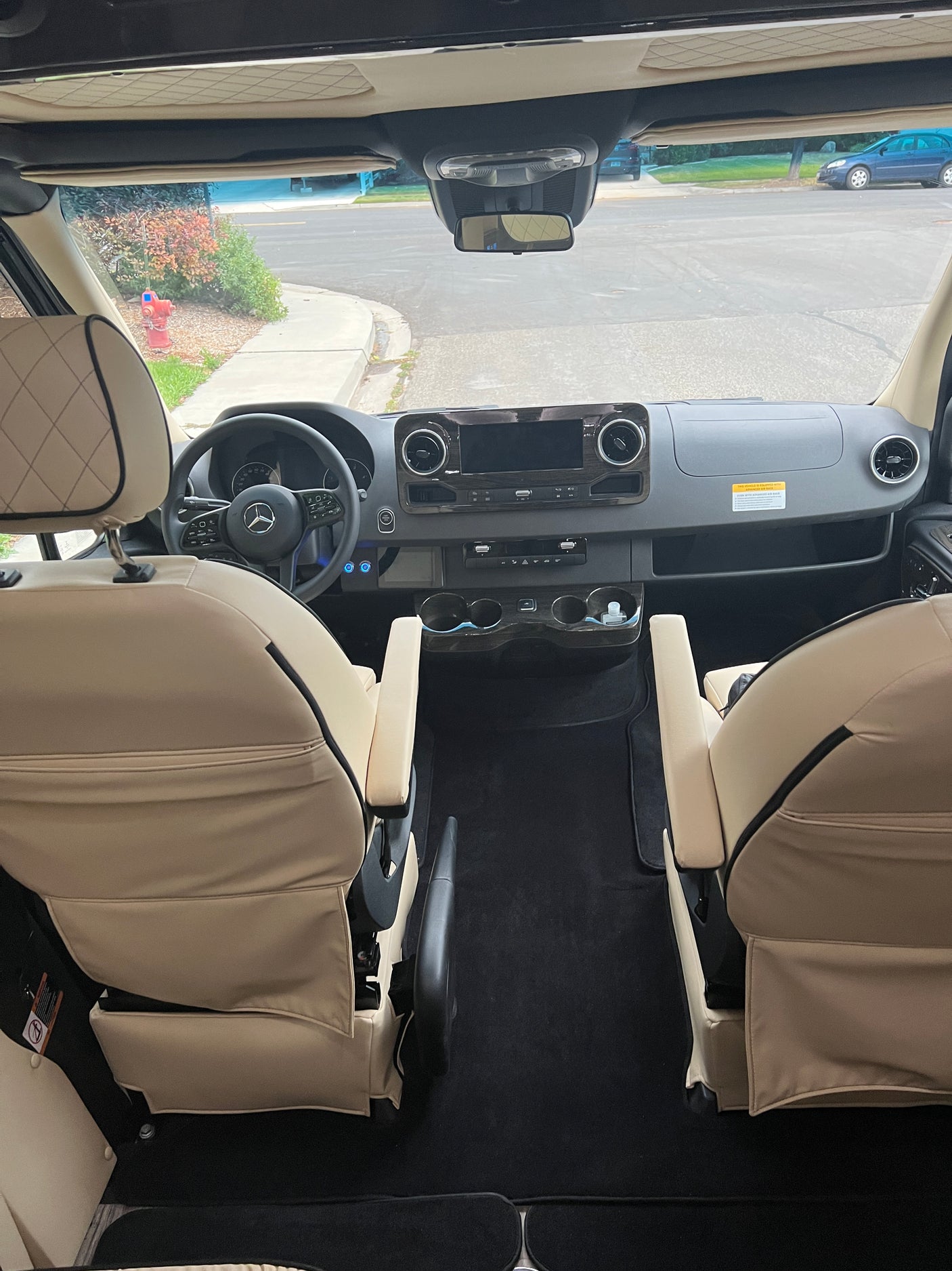 Step into this RV rental's modern cockpit. Luxurious swiveled front seats and detailed dashboard offer a comfortable, spacious interior view.