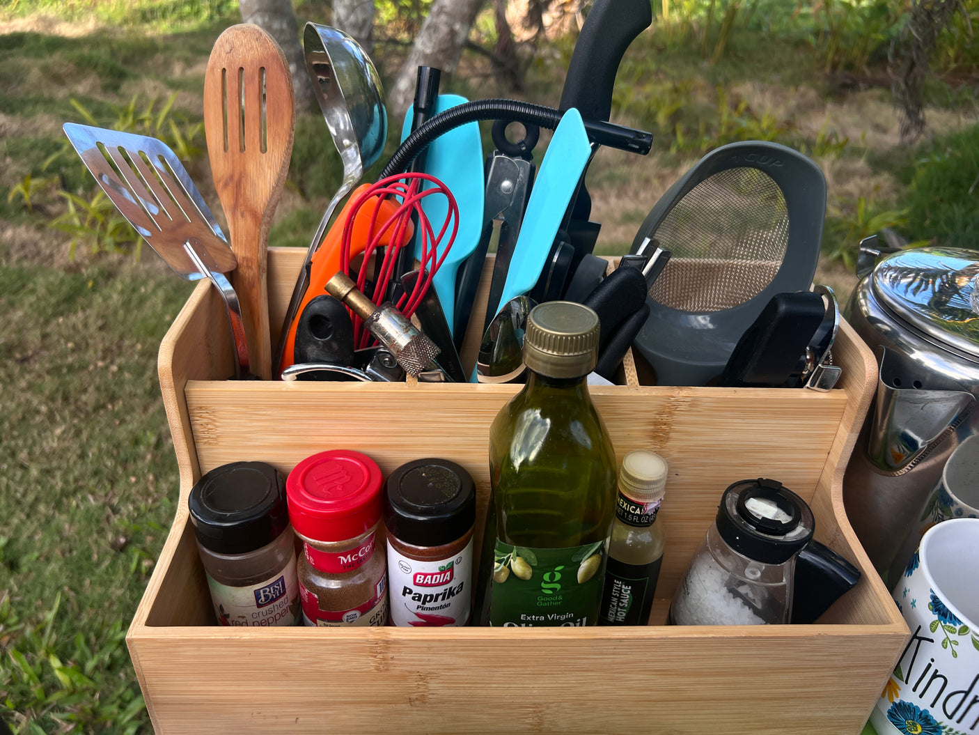 This RV rental essential caddy organizes cooking utensils, spices, and oils, perfect for camping and outdoor kitchen needs.