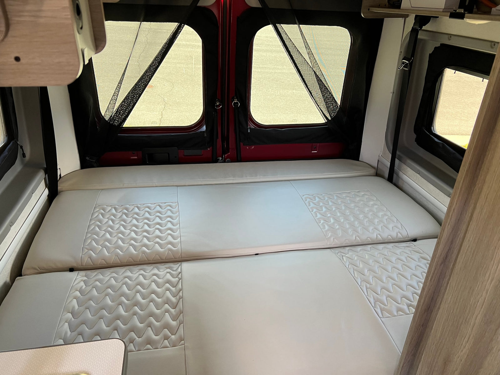 and sour cream. Cozy seats and forest views outside.|RV rental interior: Nova Kool refrigerator and a control panel with USB/12V outlets and a battery switch.|Driver's view inside an RV rental