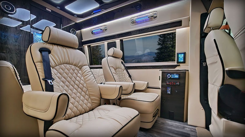 and modern design.|Luxurious RV rental interior: cream captain's chairs