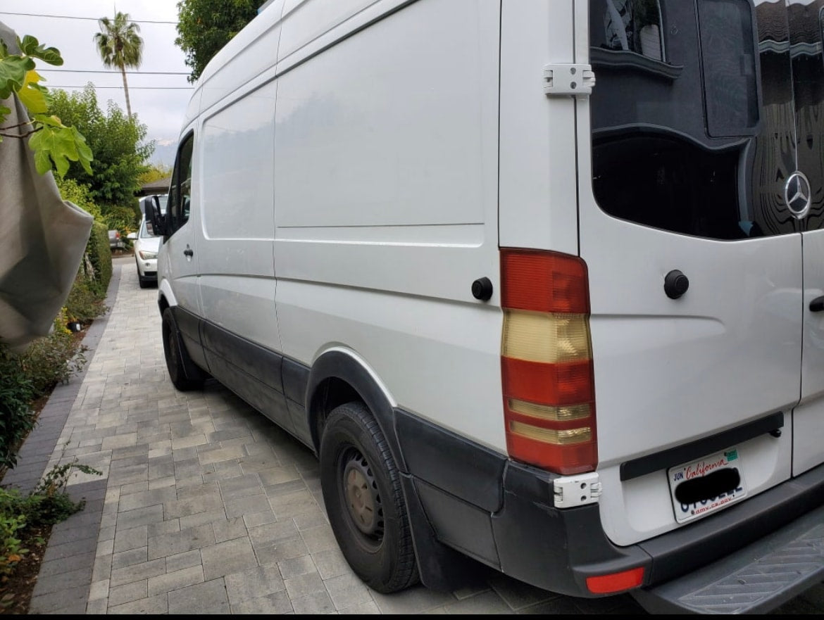 Rear-side view of a white Mercedes-Benz Sprinter van, an RV rental, on a paved driveway. — photo 9
