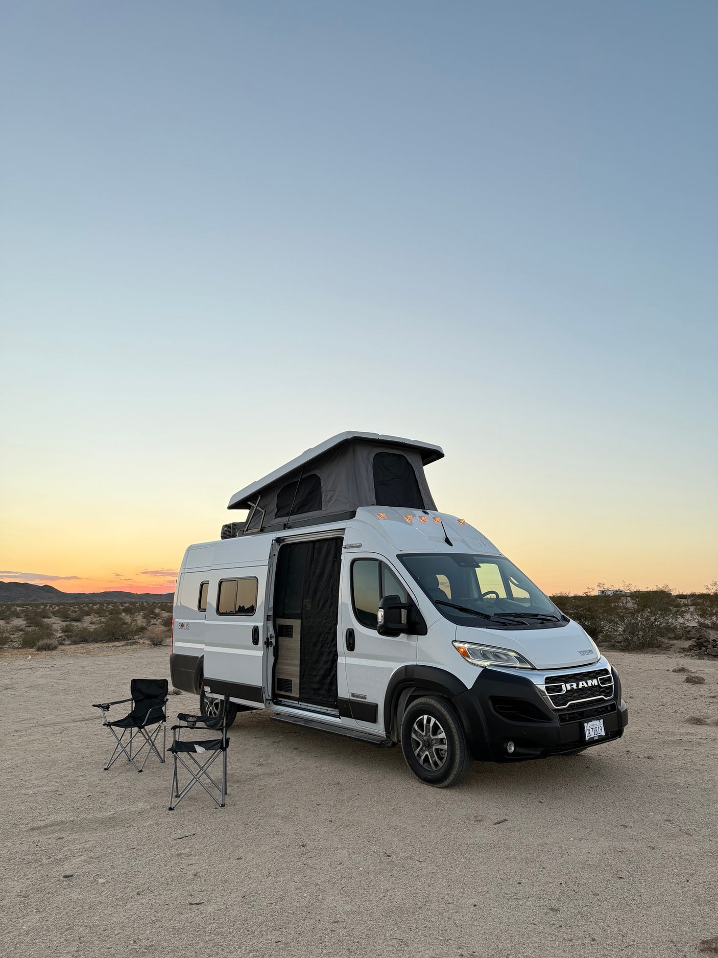 and driver's cockpit. Perfect for road trips and adventure.|Enjoying a serene desert sunset from an RV rental pop-top camper van