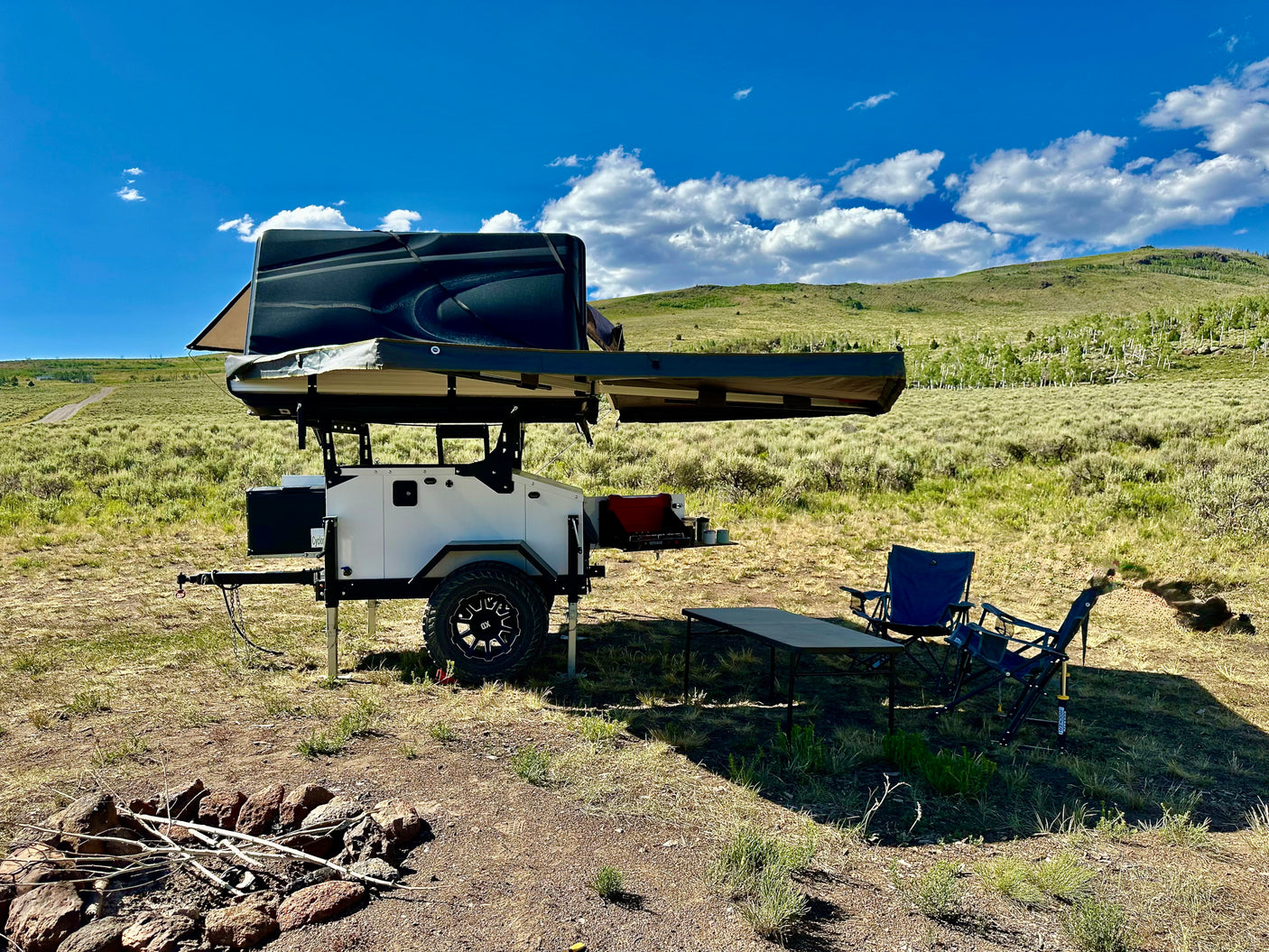 Rugged off-road overland trailer with rooftop tent setup for remote camping. Explore with this unique RV rental.