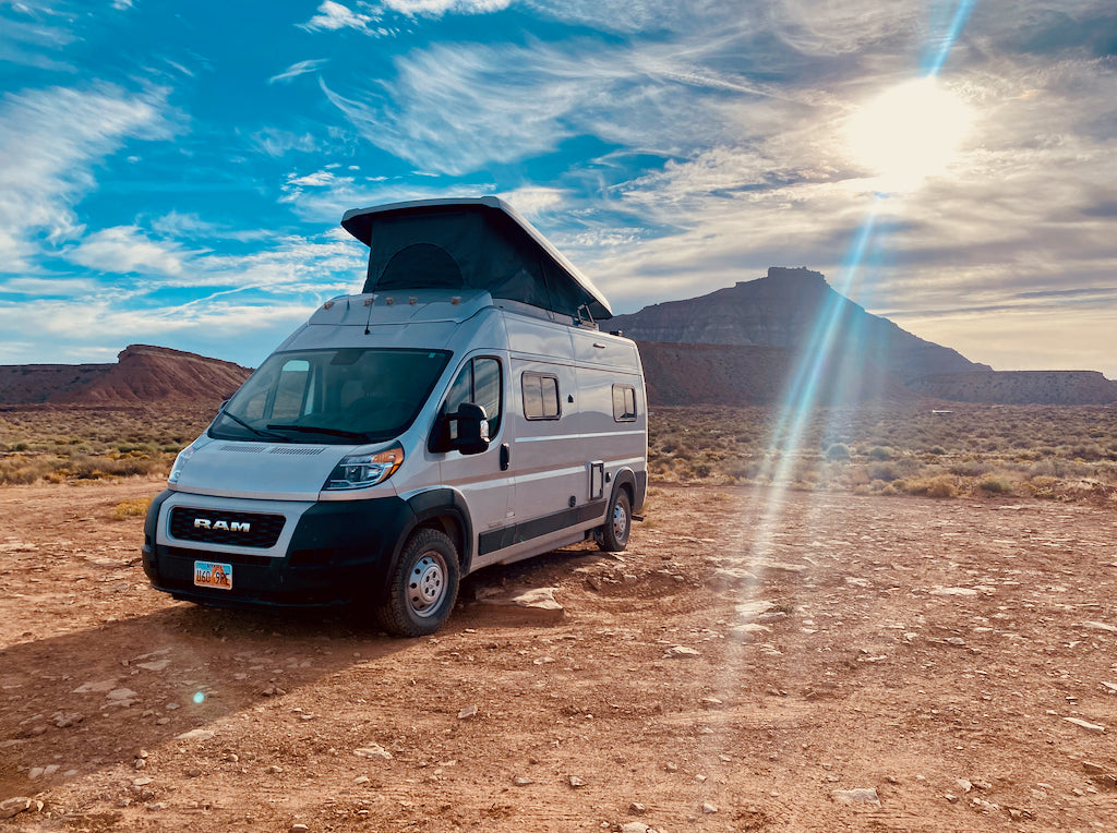 Pop-top camper van rv rental ready for desert adventure! Explore scenic wide-open spaces under a vast sky.