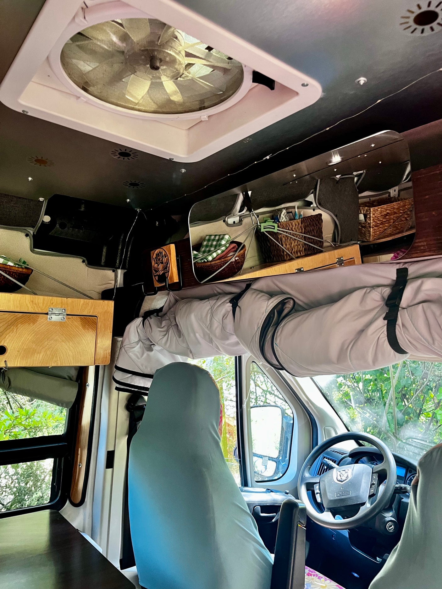 Cozy RV rental interior with overhead fan, clever storage, and driver's seat. Perfect for mobile living and road trips.