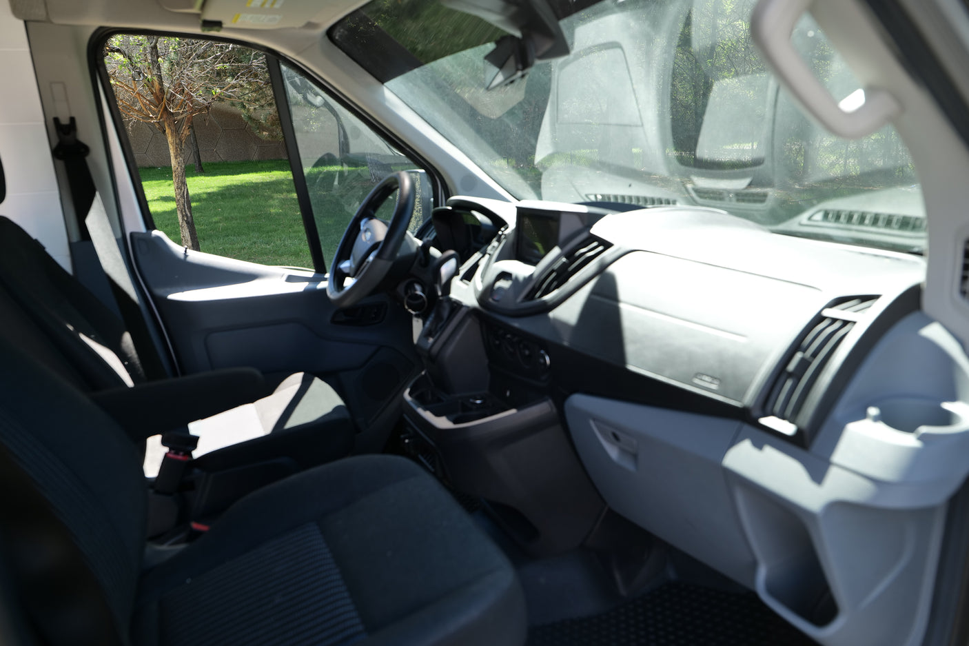 Spacious RV rental van interior, featuring the driver's cabin, dashboard, steering wheel, and front seats.