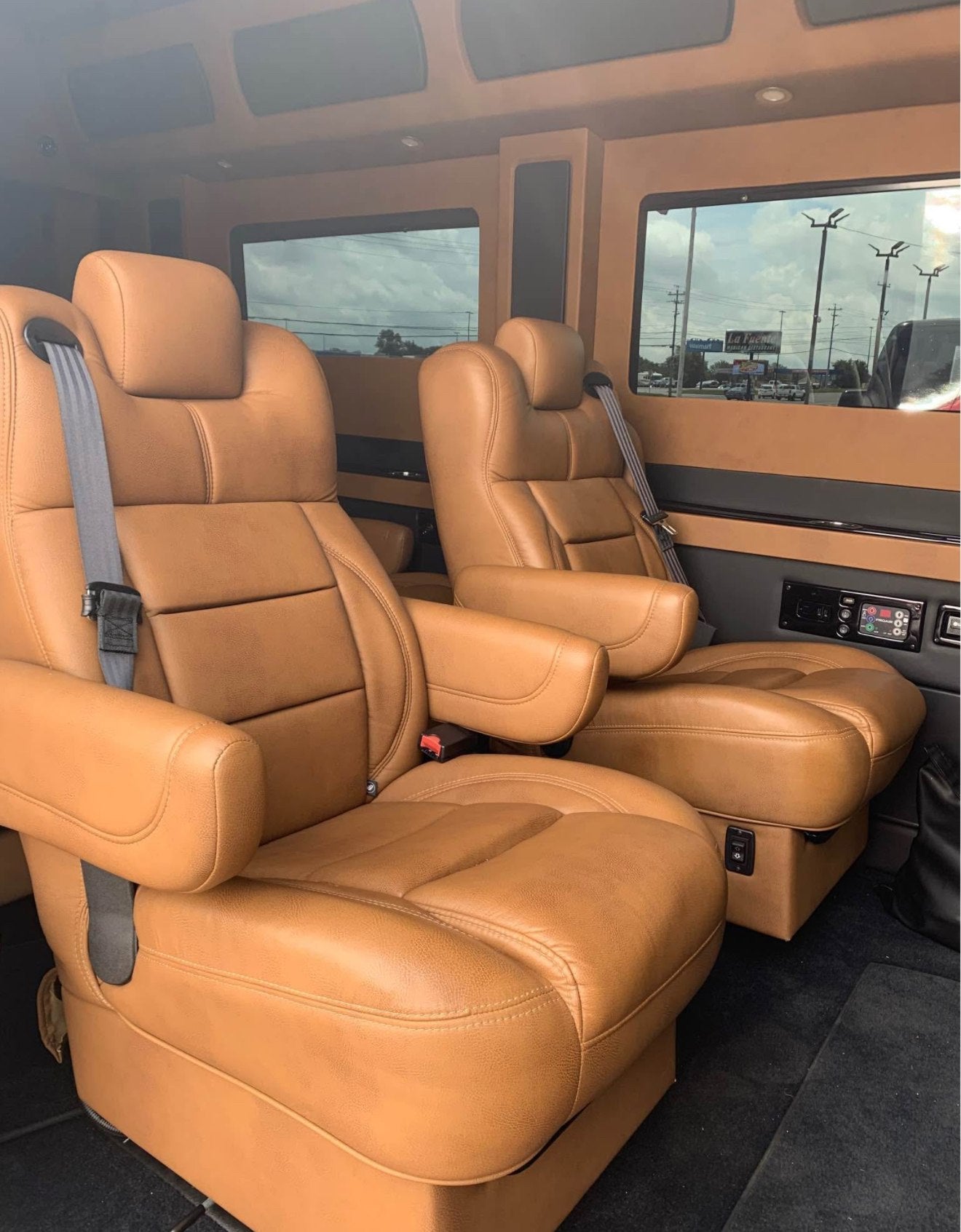 offering comfort for travel.|Experience comfort with this RV rental! Rear view of a high-end van's open interior