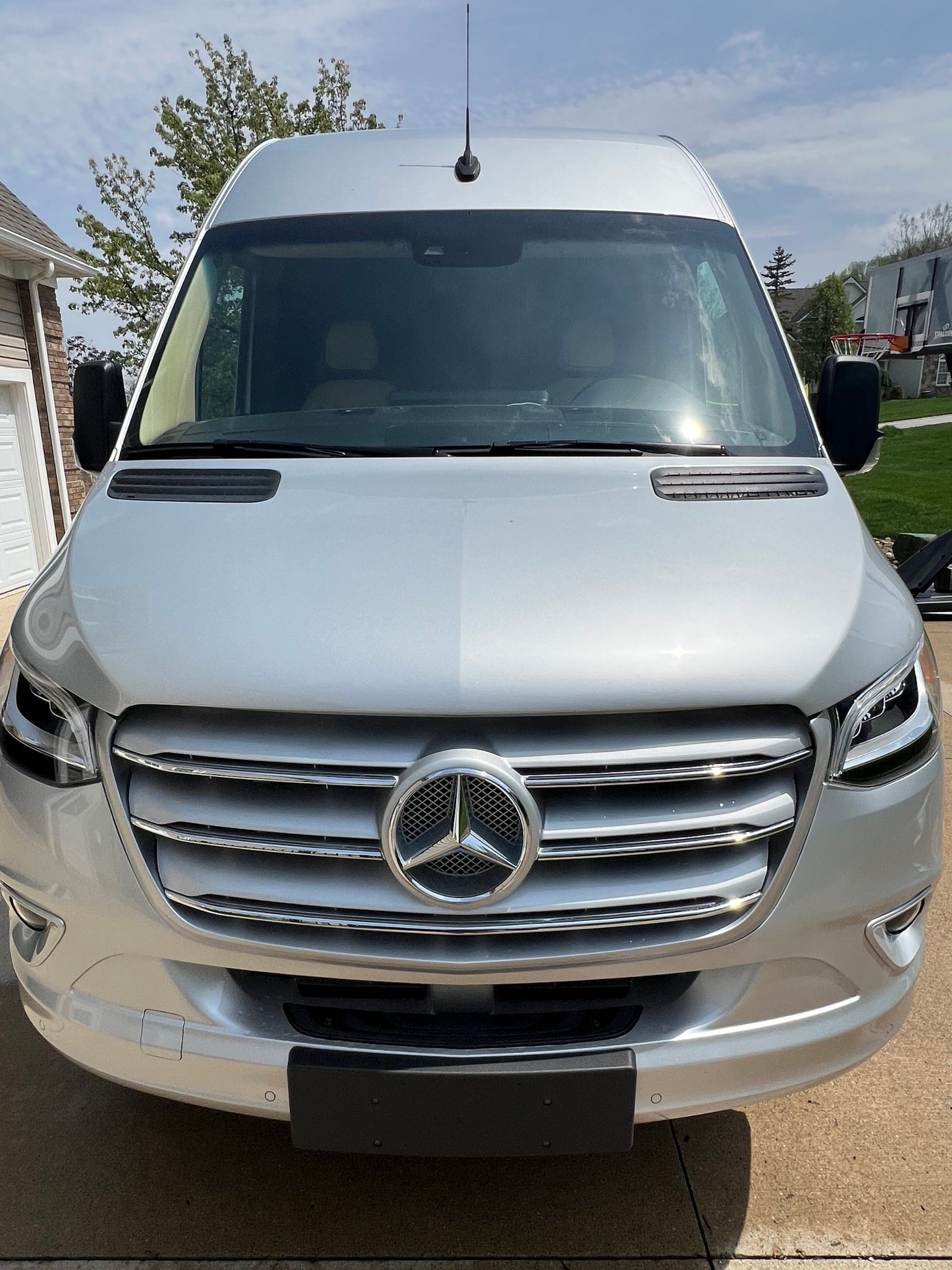 Sleek silver Mercedes-Benz Sprinter van, ideal for RV rental. Full front view of this versatile travel vehicle.