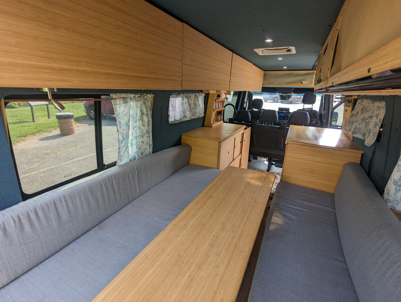 perfect for travel adventures.|Cozy RV rental: Inside a custom wood van with dining area