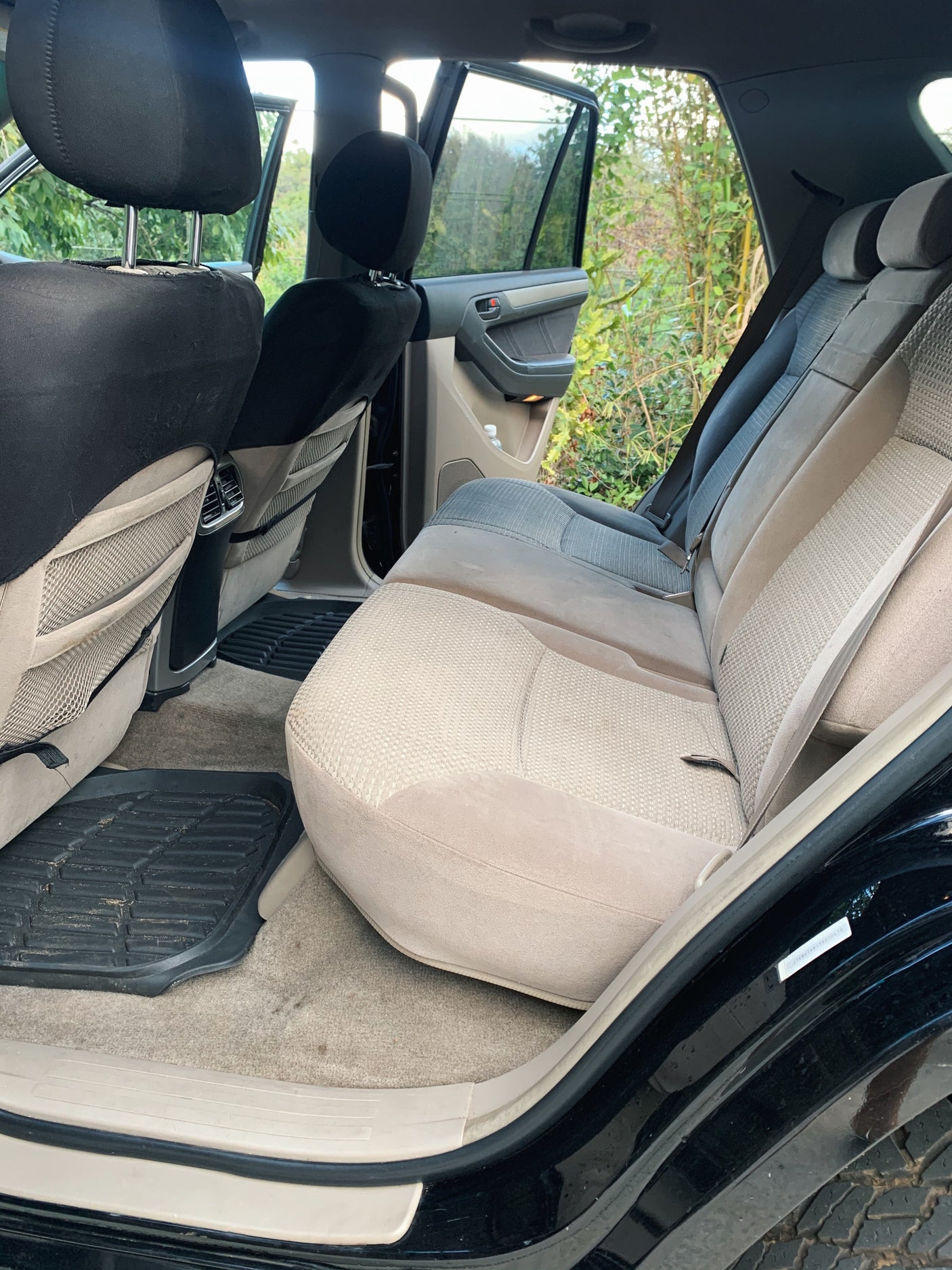 A detailed view of the beige rear seats and black floor mats inside a spacious vehicle, great for an RV rental.
