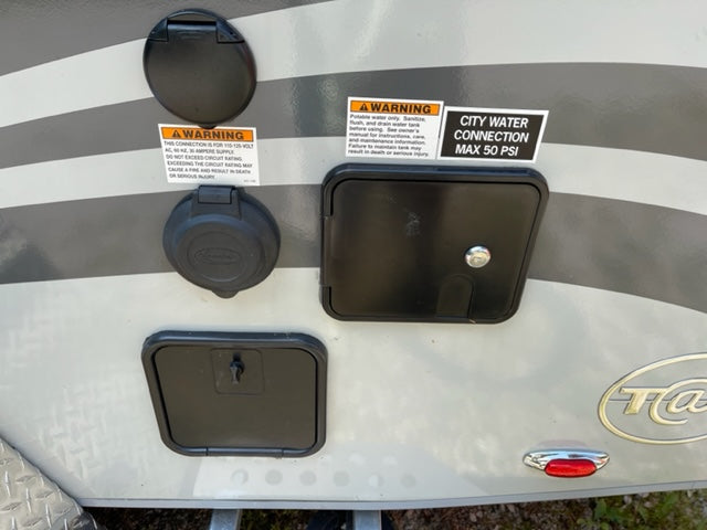 Crucial RV rental hookups: 30A power and city water (max 50 PSI) connections, plus lower service access points.