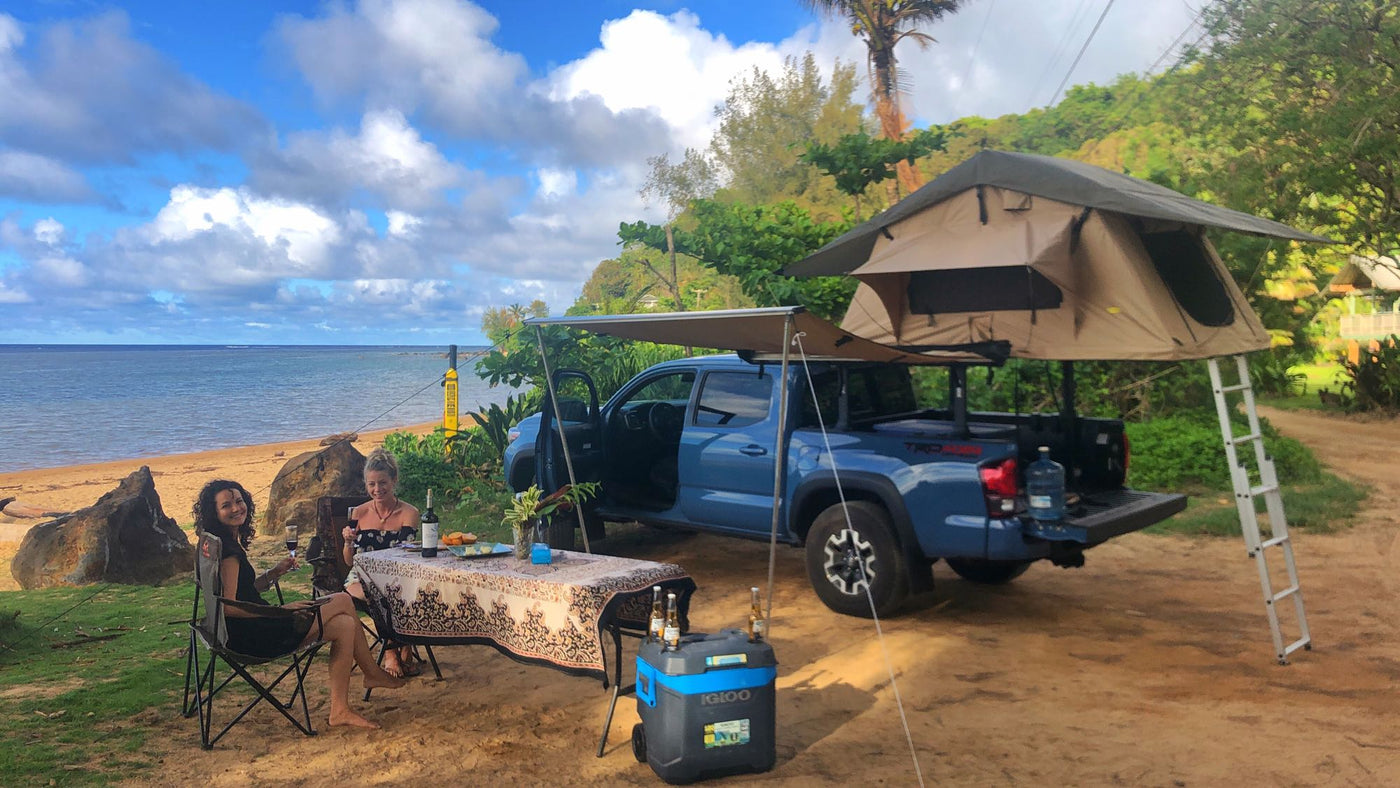 Coastal glamping with a truck, rooftop tent, and awning. Two women relaxing by the beach. An outdoor escape for any rv rental style. — photo 2