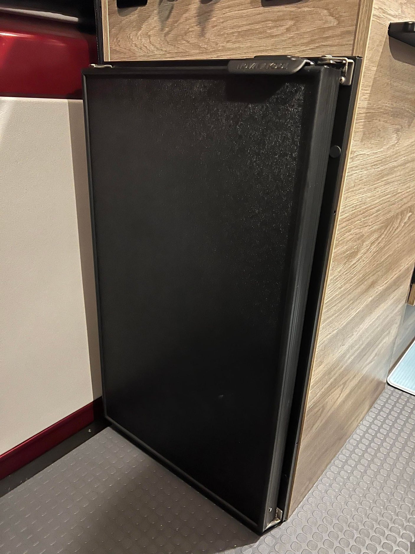 Black, built-in compact refrigerator in an RV rental, perfect for keeping food cool on the go.