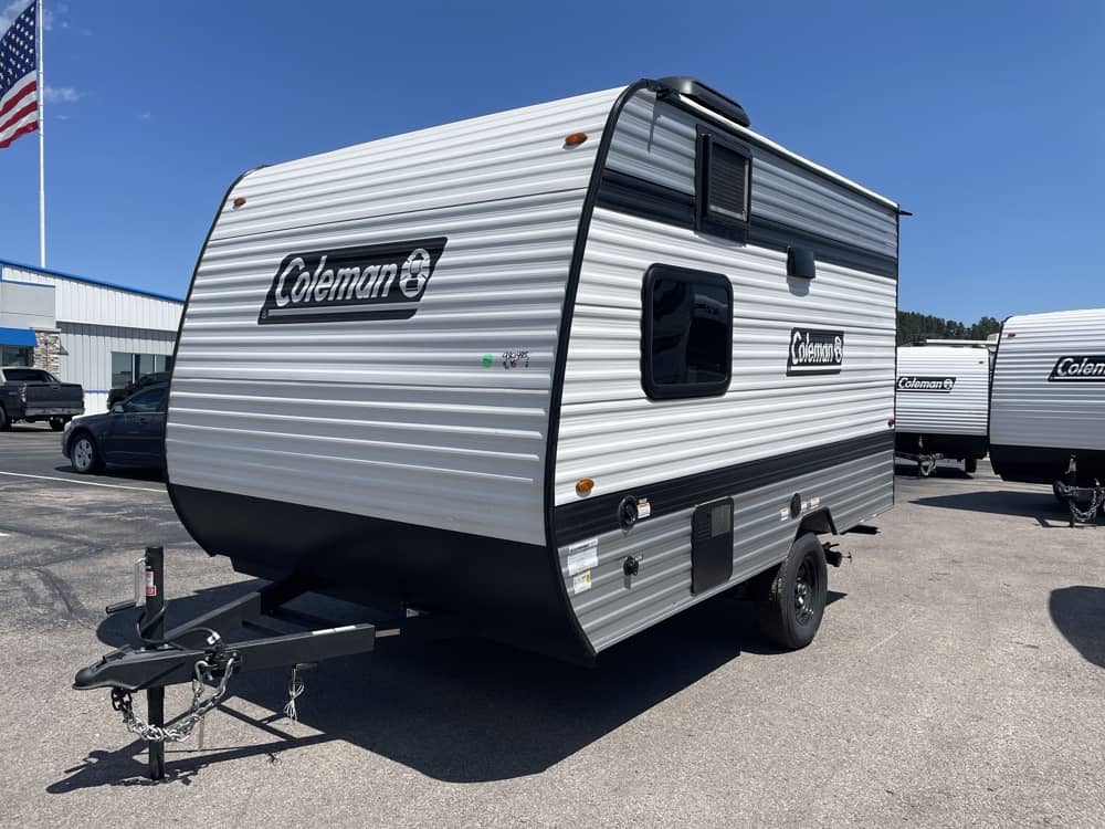 This white/grey Coleman RV rental travel trailer is ready for camping adventures.|Coleman travel trailer perfect for an rv rental. This silver RV features a door
