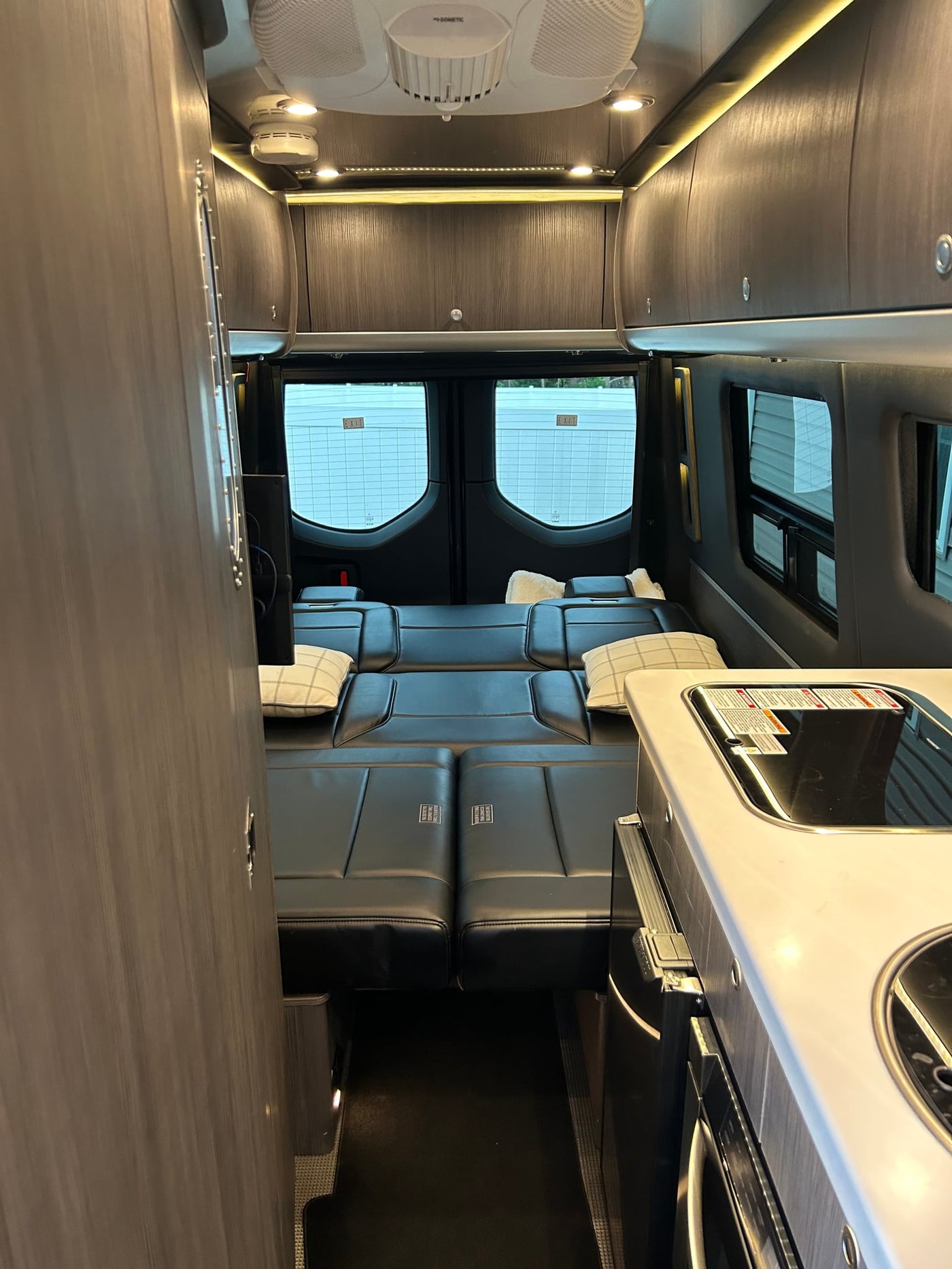 and window.|Inside a premium RV rental: modern kitchen with cooktop — photo 9