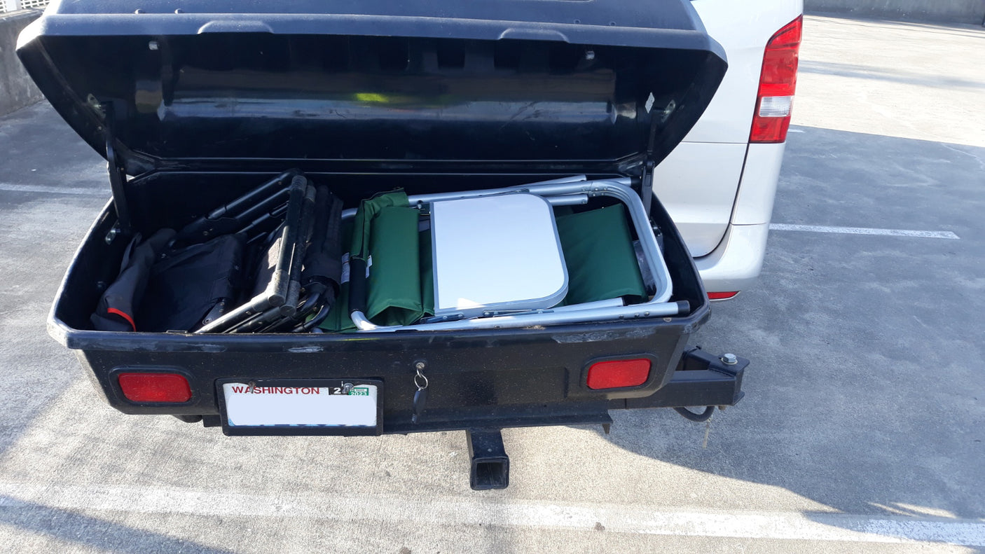 This RV rental features an open rear cargo box, loaded with essential camping chairs and a small table for your travels.