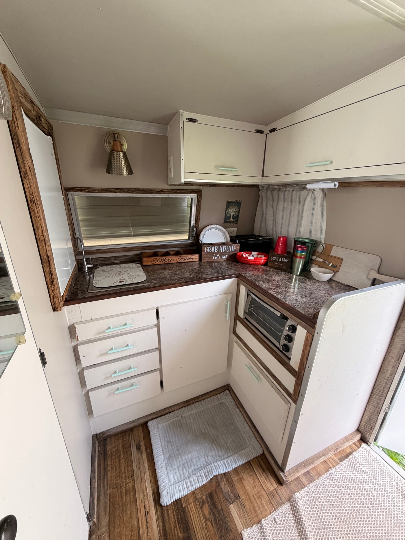 Cozy RV rental kitchen featuring a sink, cabinets, toaster oven, and a "S'Mores Station" ready for camping adventures. — photo 3
