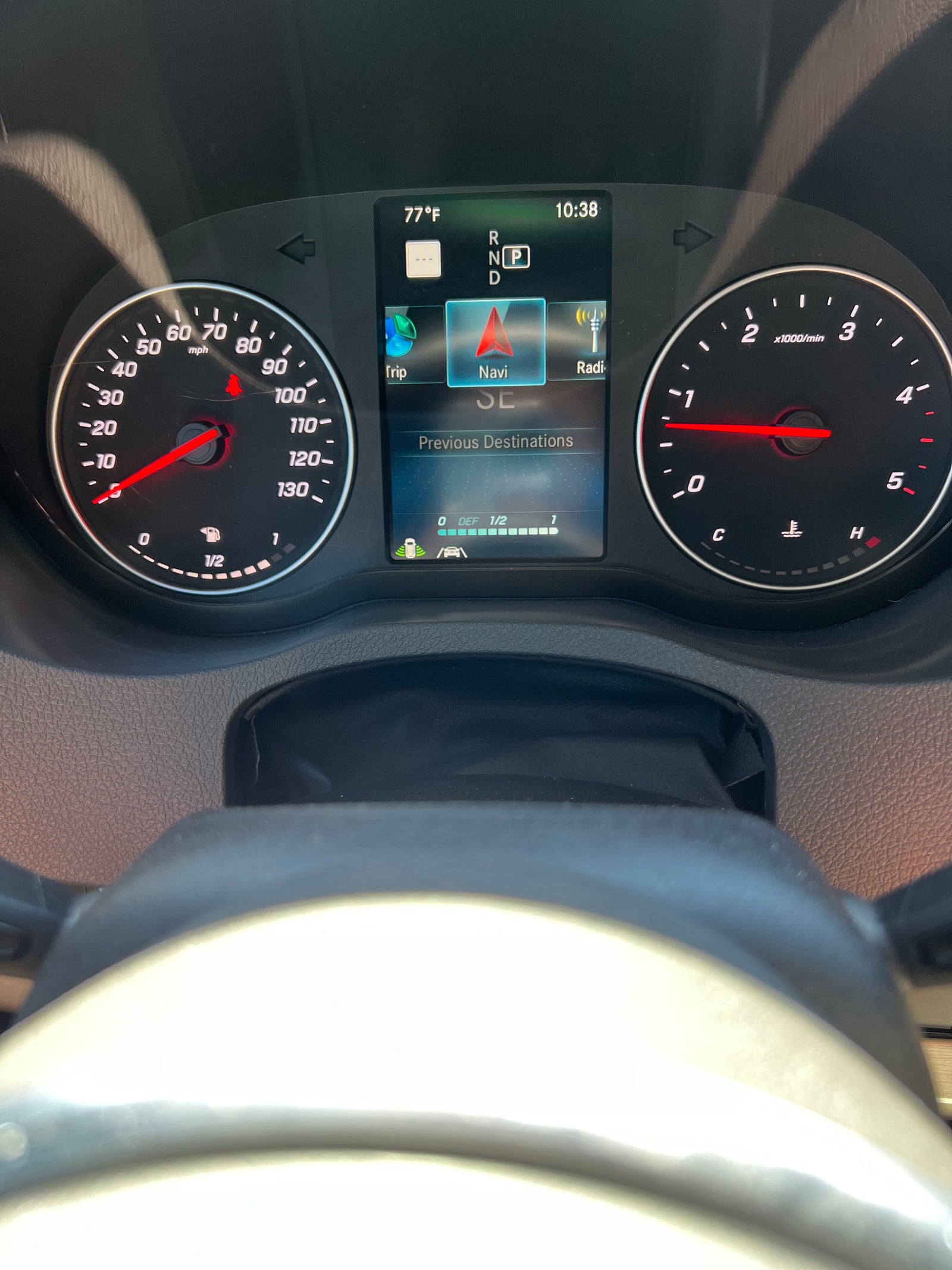 Dashboard of an RV rental vehicle showing speedometer, navigation, and fuel gauges. Temperature is 77°F and time is 10:38.