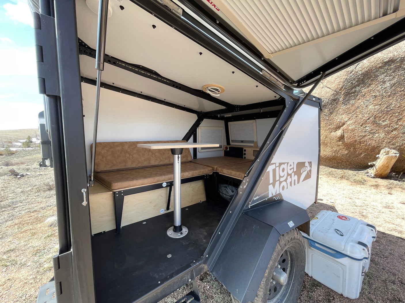 Compact Tiger Moth RV rental interior featuring a dinette converting to a bed, ideal for outdoor adventures.