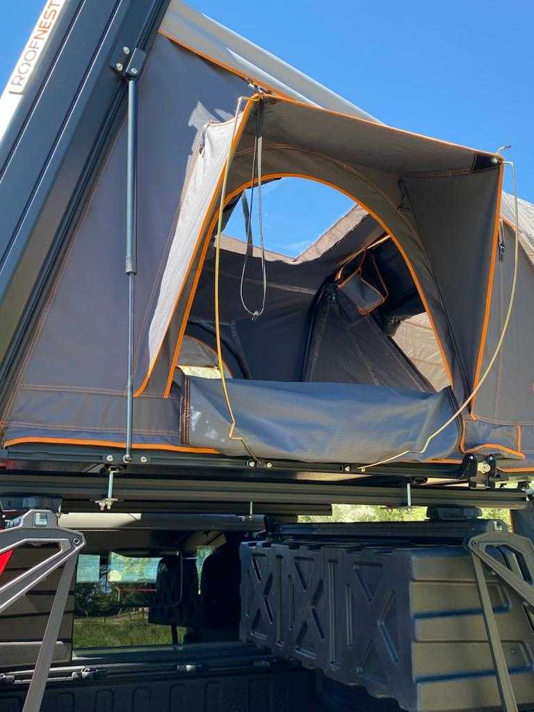 by the river. Ideal for camping.|This **RV rental** features a rooftop tent mounted on a truck — photo 10