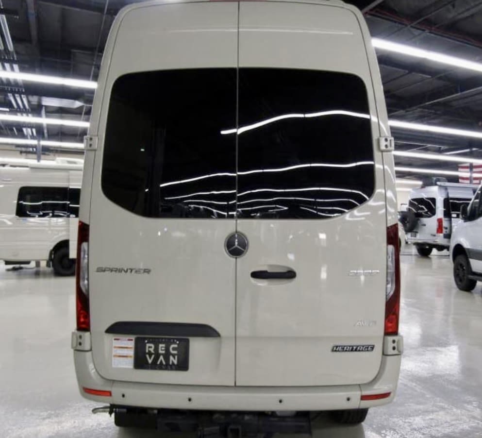 Rear view of a white Mercedes Sprinter RV rental van, featuring tinted windows, Mercedes logo, AWD, and "HERITAGE" badges. — photo 2